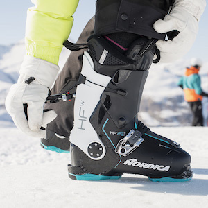 Personne qui chausse une chaussure de ski